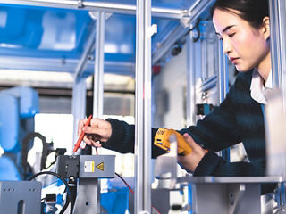 Female Engineer testing medical connectors in a high-tech research laboratory with modern equipment.