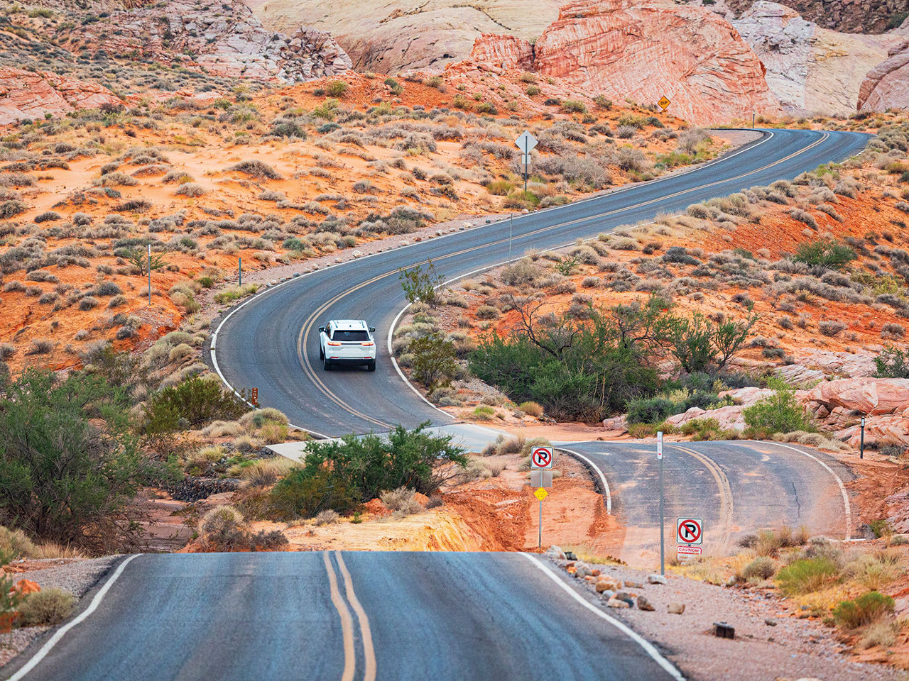 A car driving through a desert landscape. 