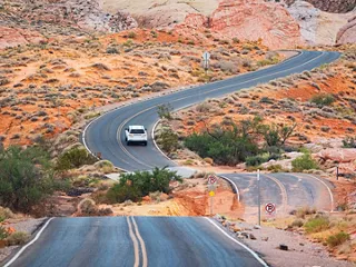 A car driving through a desert landscape. 