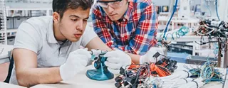 Engineers inspecting crimped terminals with a digital crimp micrometer.