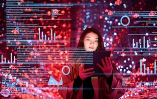 タブレットを使用する女性とデータのグラフィック画像。