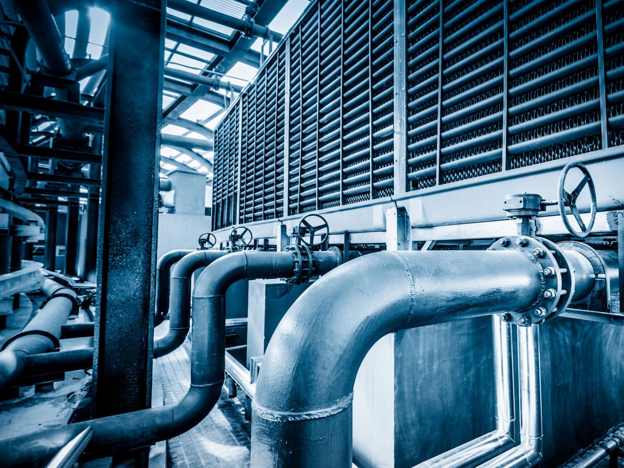Large-scale industrial HVAC system with visible pipes and valves. 