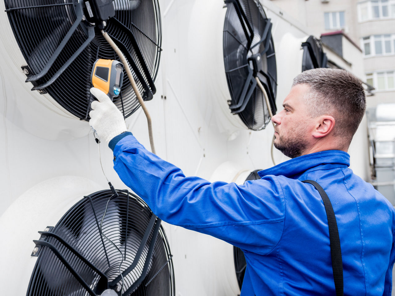 Technician testing HVAC unit performance using diagnostic equipment. 