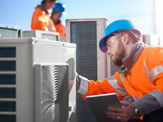 Workers assessing commercial HVAC equipment 