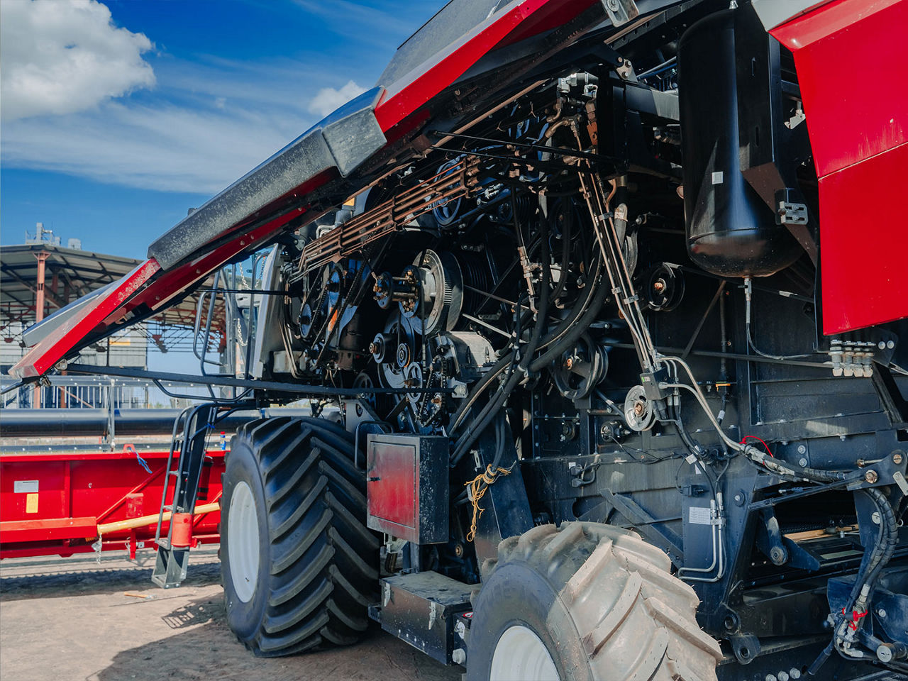 View of a heavy equipment combine harvester engine compartment showing complex wiring harnesses, sensors and structural framework.