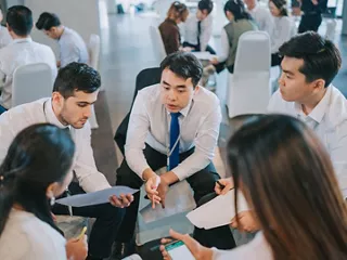 Professionals collaborating in small groups at an event.