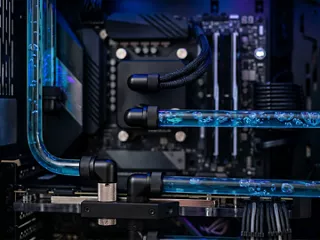 Close-up of liquid-cooling tubes circulating coolant around electronic components inside a high-performance computing system. 