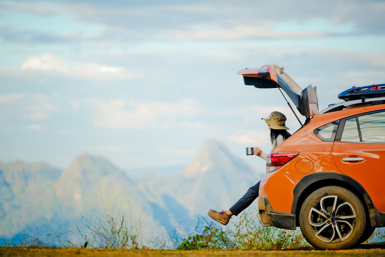 woman traveler in motion of enjoying takes a look scenery view on the peak of mountain at the morning light, joyful taking mind cheerfully with set of hot coffee time on the cliff of mountain, hight range of the risk area camping with the car transport belong