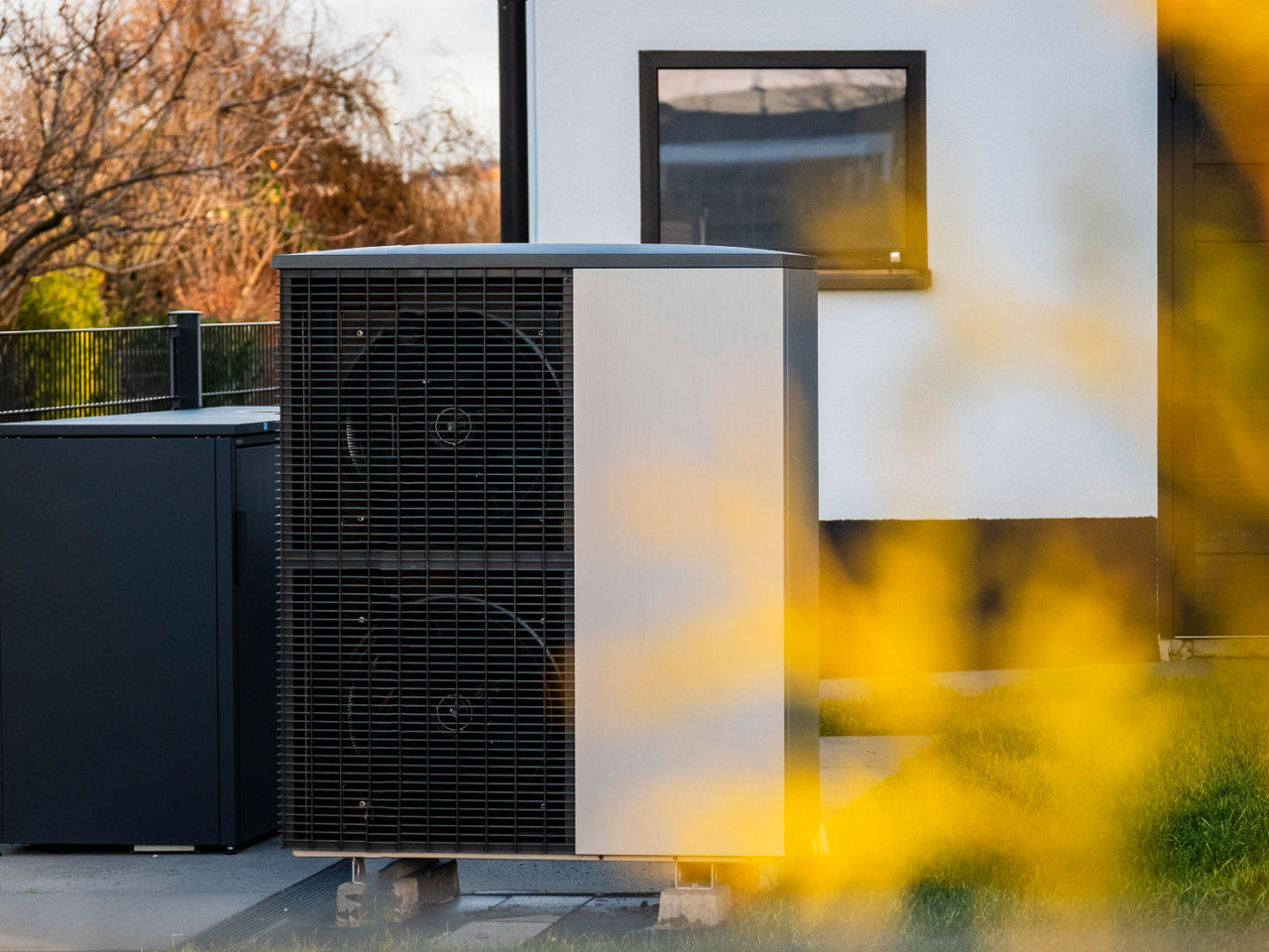 Outdoor residential HVAC unit next to a modern house. 