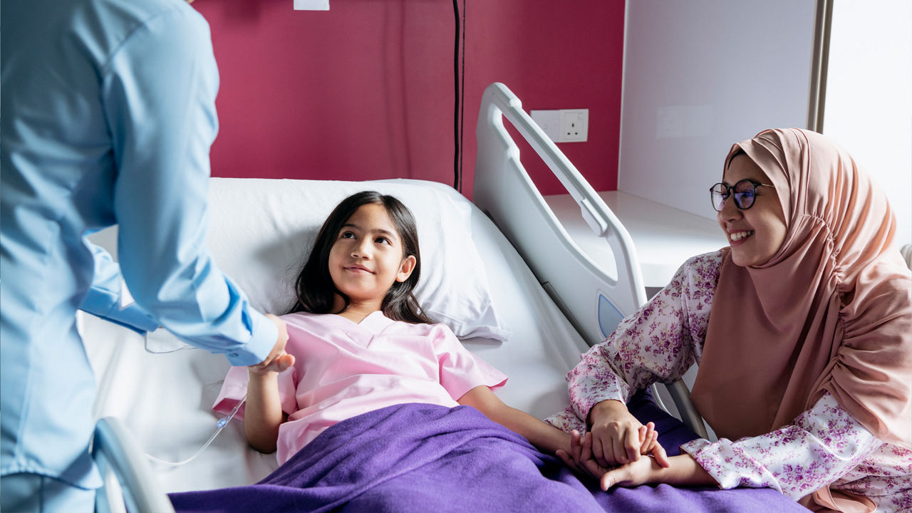 母親に付き添われ、医療従事者から診療を受ける幼い子ども。