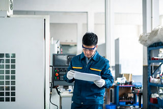 A male worker looks at the drawings in the factory