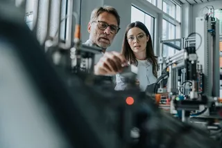 Two engineers collaborating on a prototype.   