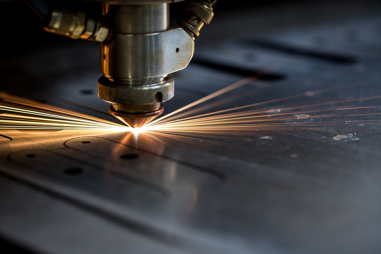 Cutting of metal. Sparks fly from laser, close-up